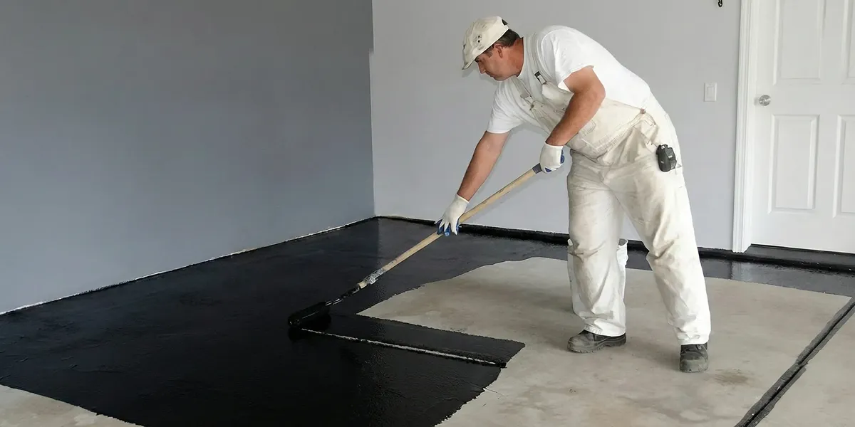 basement waterproofing professional applying waterproof coating to protect a basement floor in Jersey City, NJ